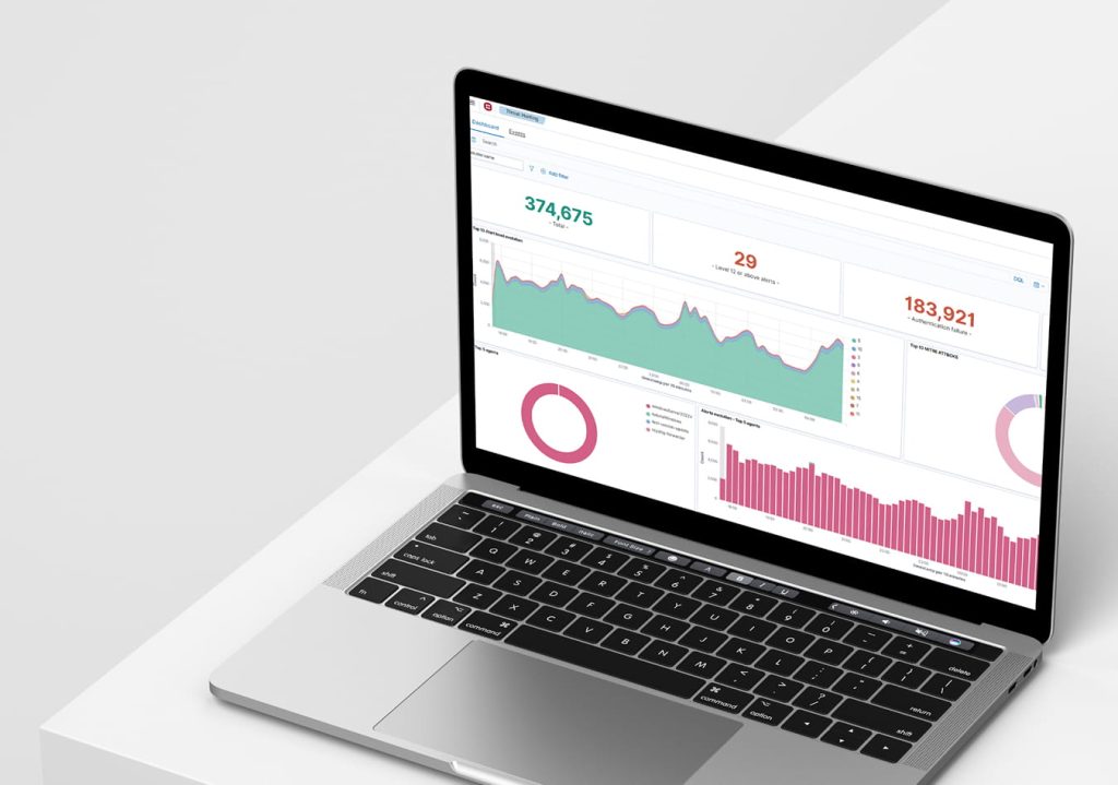 A laptop displaying a data analytics dashboard with multiple charts, including a line graph showing fluctuating trends, a bar chart comparing category values, and two donut charts illustrating proportional data. Large numerical metrics such as “374,675,” “29,” and “183,921” appear above the charts, indicating key performance indicators.